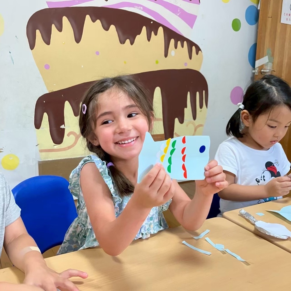 A child smiling with a handmade craft