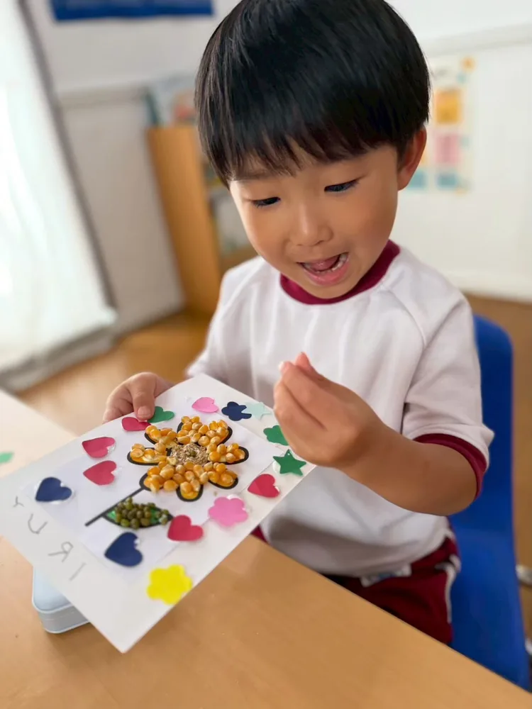 A child showing a handmade flower craft in afternoon classes