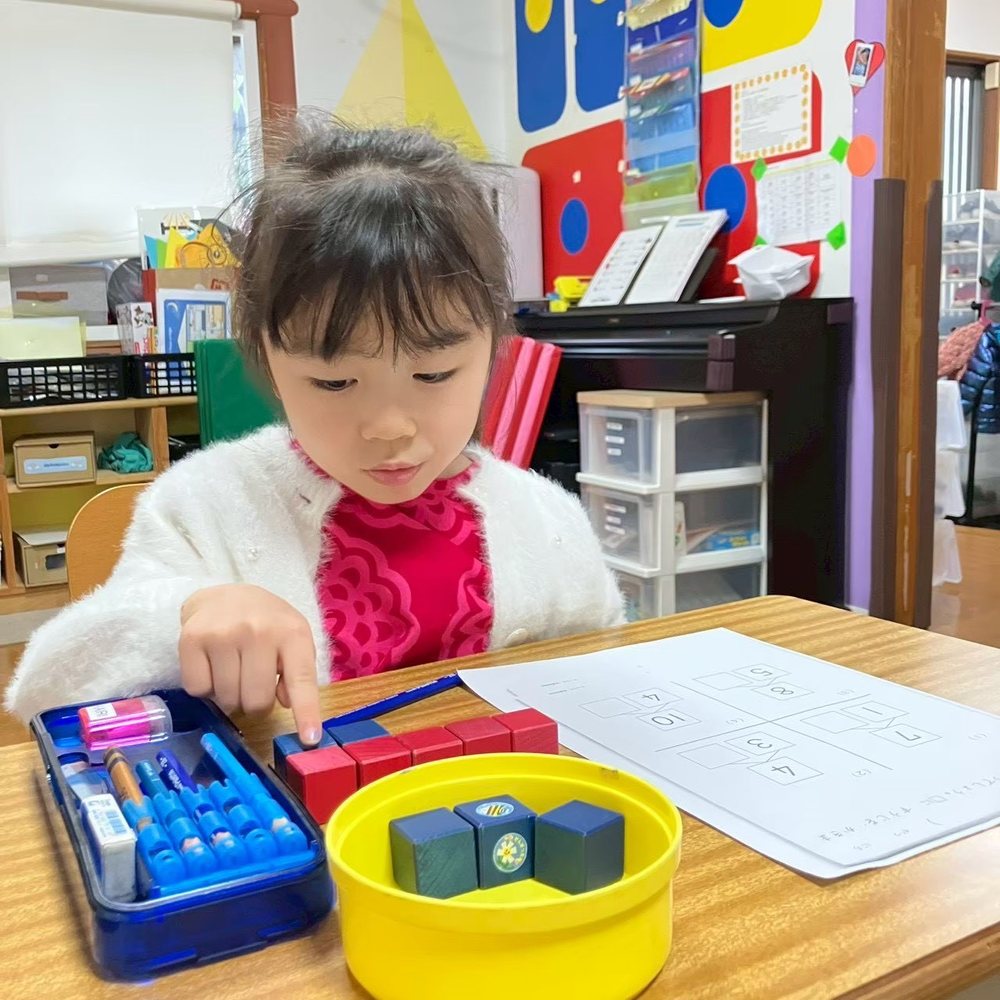 A child working on crafts and dexterity tasks in the exam-prep class