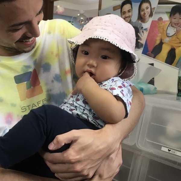 先生に抱っこされる乳児の在園児